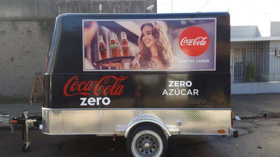 Trailer de OCHO ploteado de punta a punta con la gráfica de Coca-Cola Zero, con la lanza de remolque y la rueda jockey a la vista