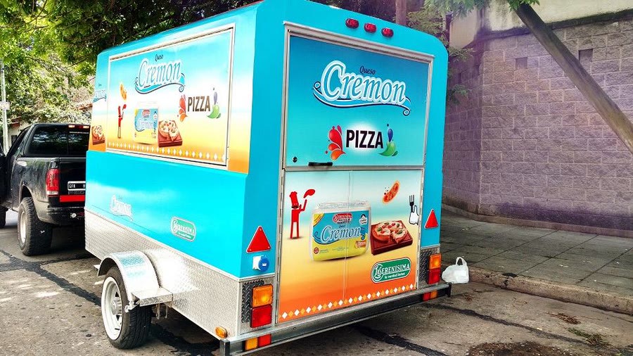Trailer de OCHO ploteado con la gráfica de Queso Cremon, visto desde atrás con las puertas cerradas